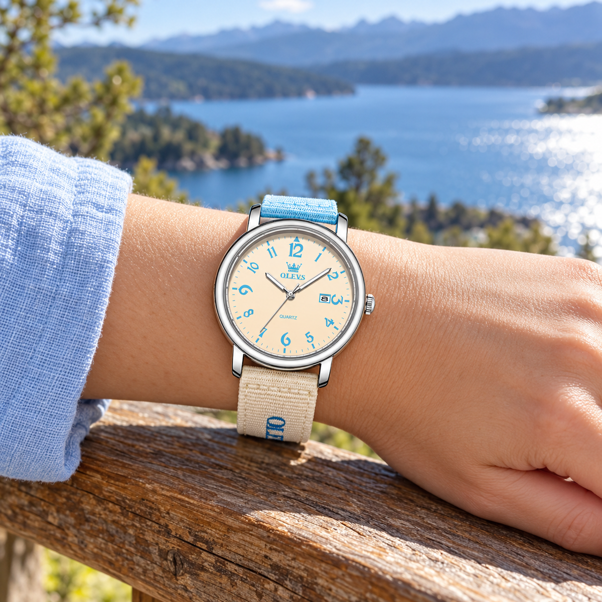 Mujer usando el reloj OLEVS 2991 celeste y beige frente al mar al atardecer